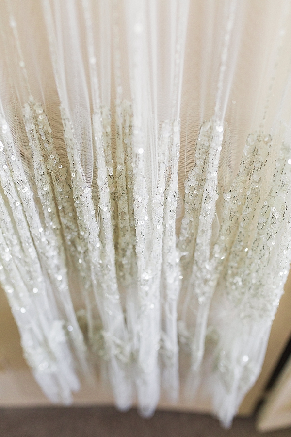 boho vintage style wedding festival jenny packham fine art documentary wedding photography cotswolds gloucester cheltenham photo shows the dress hanging and sequins from the dress catching the light. image by hayley morris photography