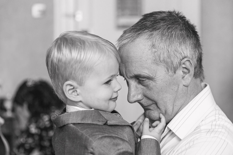 photograph shows a grandfather with his head against his grandson on the morning of his daughter's wedding day. Image by hayley morris photography - puckrup hall tewkesbury gloucester gloucestershire cotswolds hilton wedding photography fine art wedding photographer emotions
