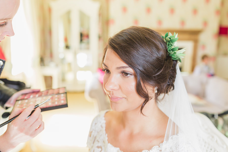 finishing touches of a bride having her makeup applied before her wedding blessing - image by hayley morris photography - fine art documentary wedding photography light airy photographer worcester west midlands