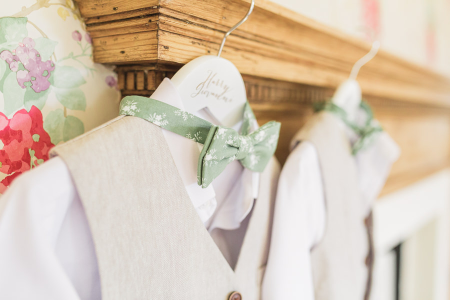 fine art wedding photography italy Italian - image shows two page boy suits with sage bow ties hanging from a fireplace - image by hayley morris photography 