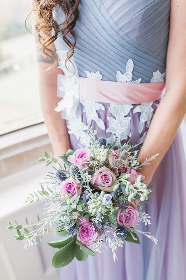 fine art wedding photography whitney court herefordshire - bride in a heather coloured light and pastel dress holding her bouquet - wedding at Whitney court in herefordshire near wales - image by hayley morris photography