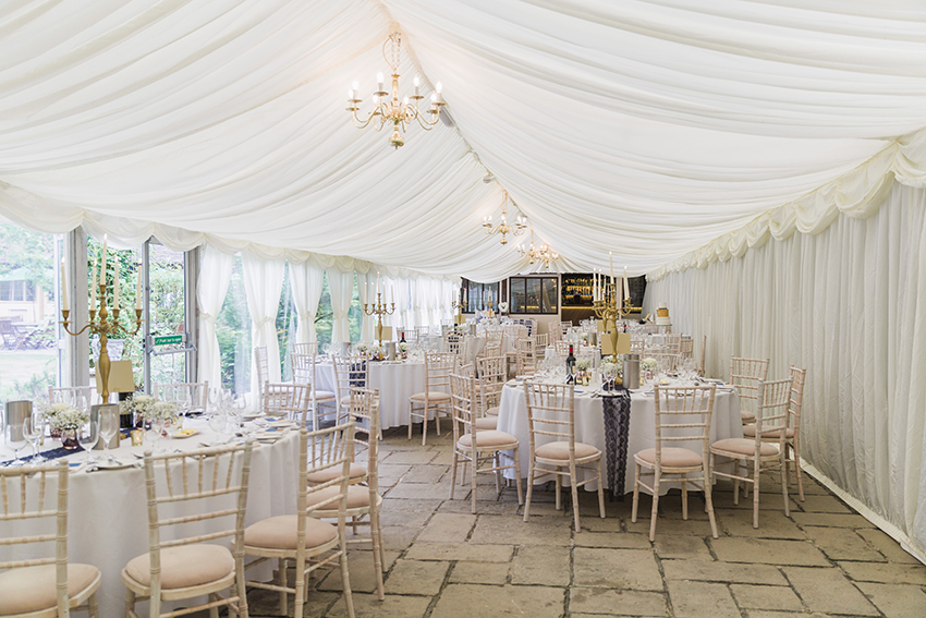 Full room view inside the marquee at Birtsmorton Court with the area set up for a wedding breakfast
