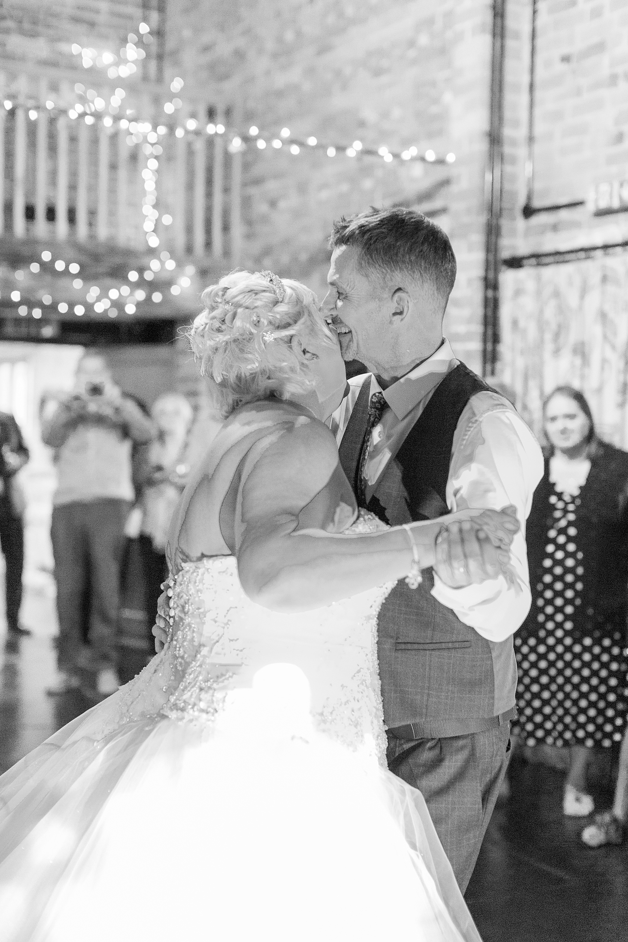 Photo of a bride and groom dancing their first dance at their wedding in a barn at curradine barns