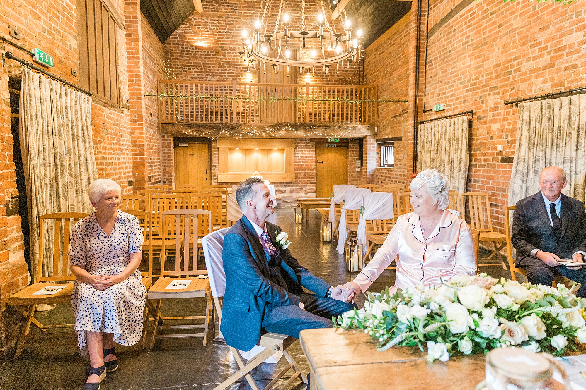 bride dressed in silk pyjamas and groom in his wedding attire having a private wedding ceremony ahead of their humanist ceremony at curradine barns 