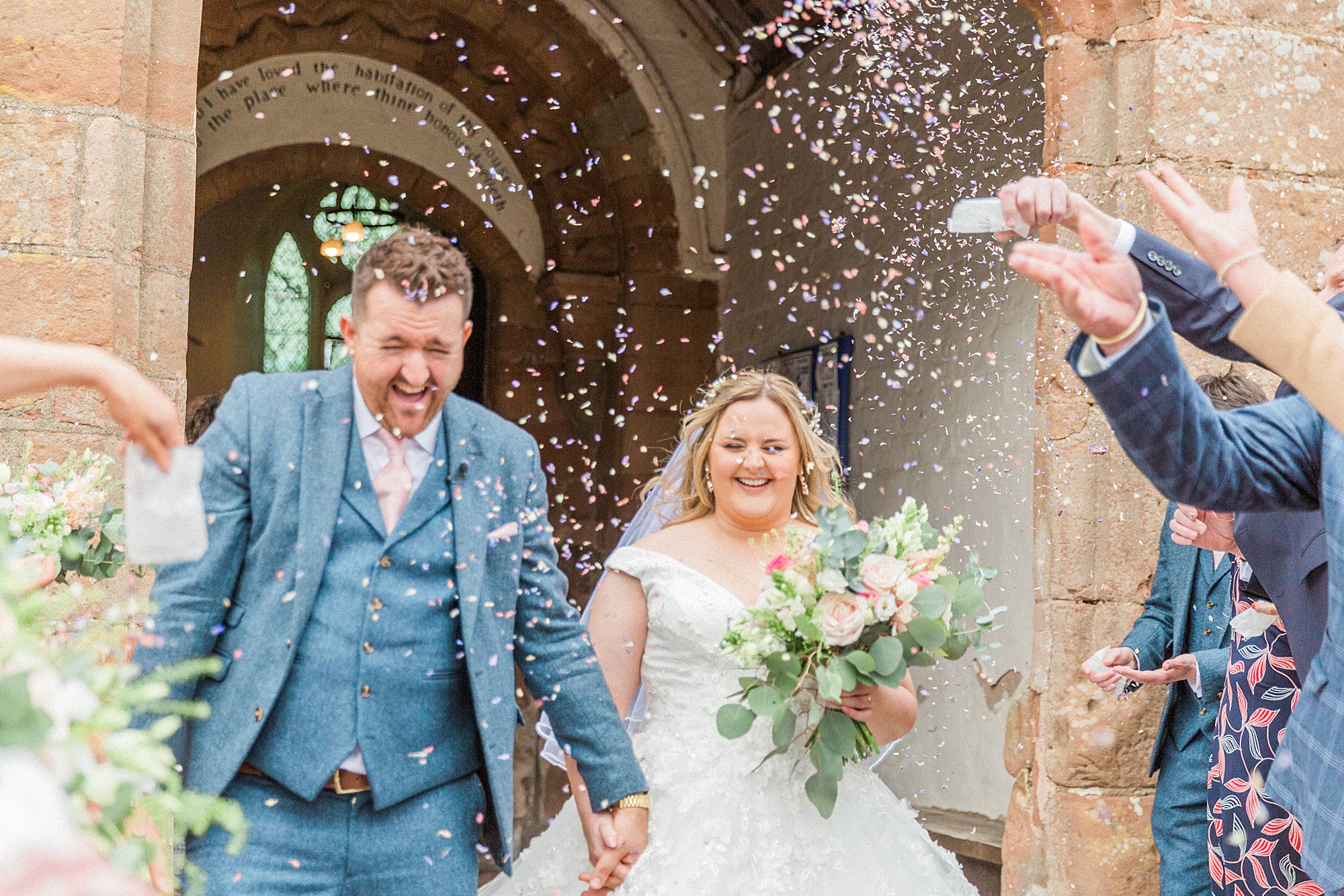 photo of a bride and groom leaving the church under a flurry of confetti