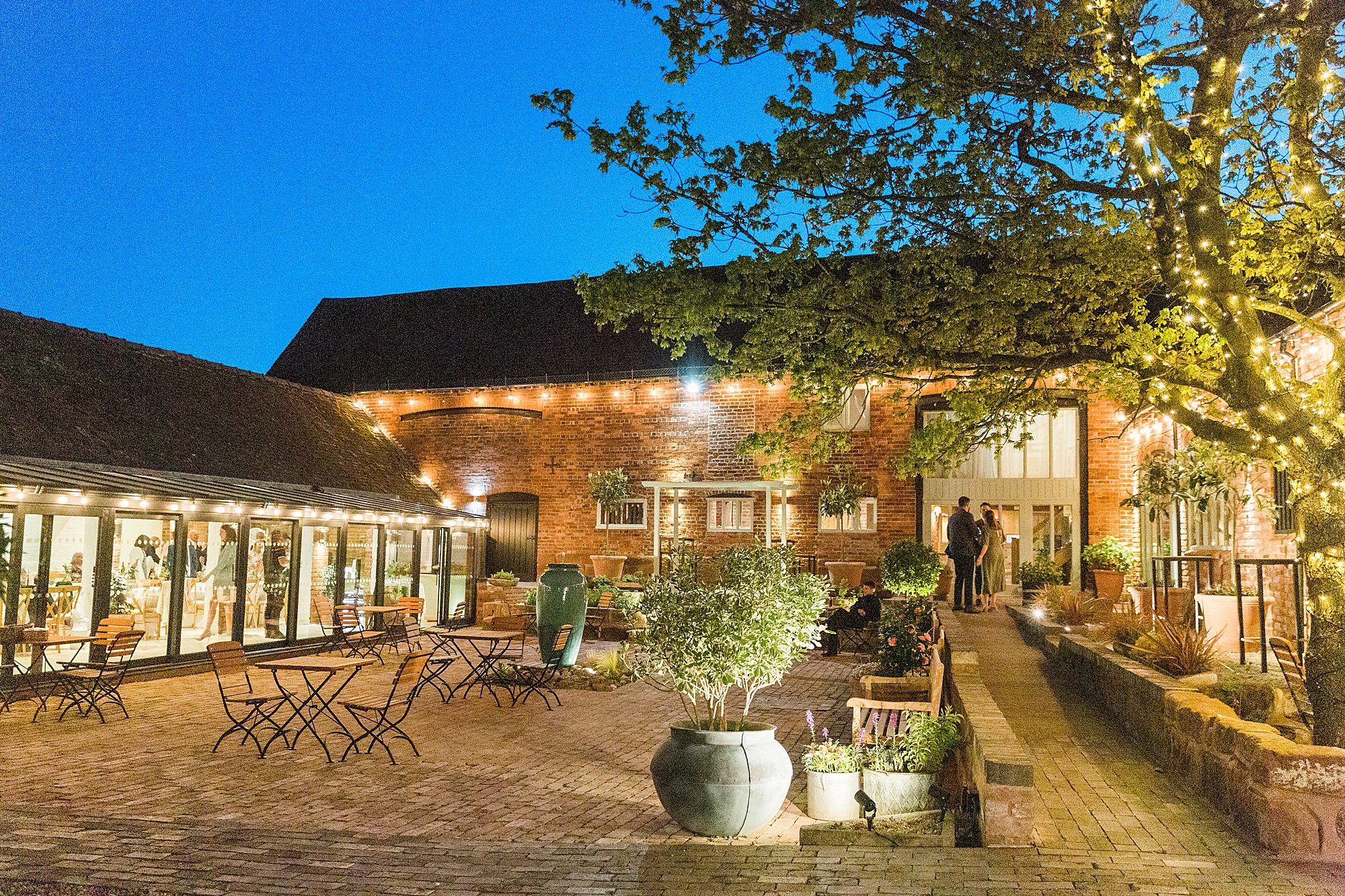 photo of the exterior of curradine barns in the evening all lit up 