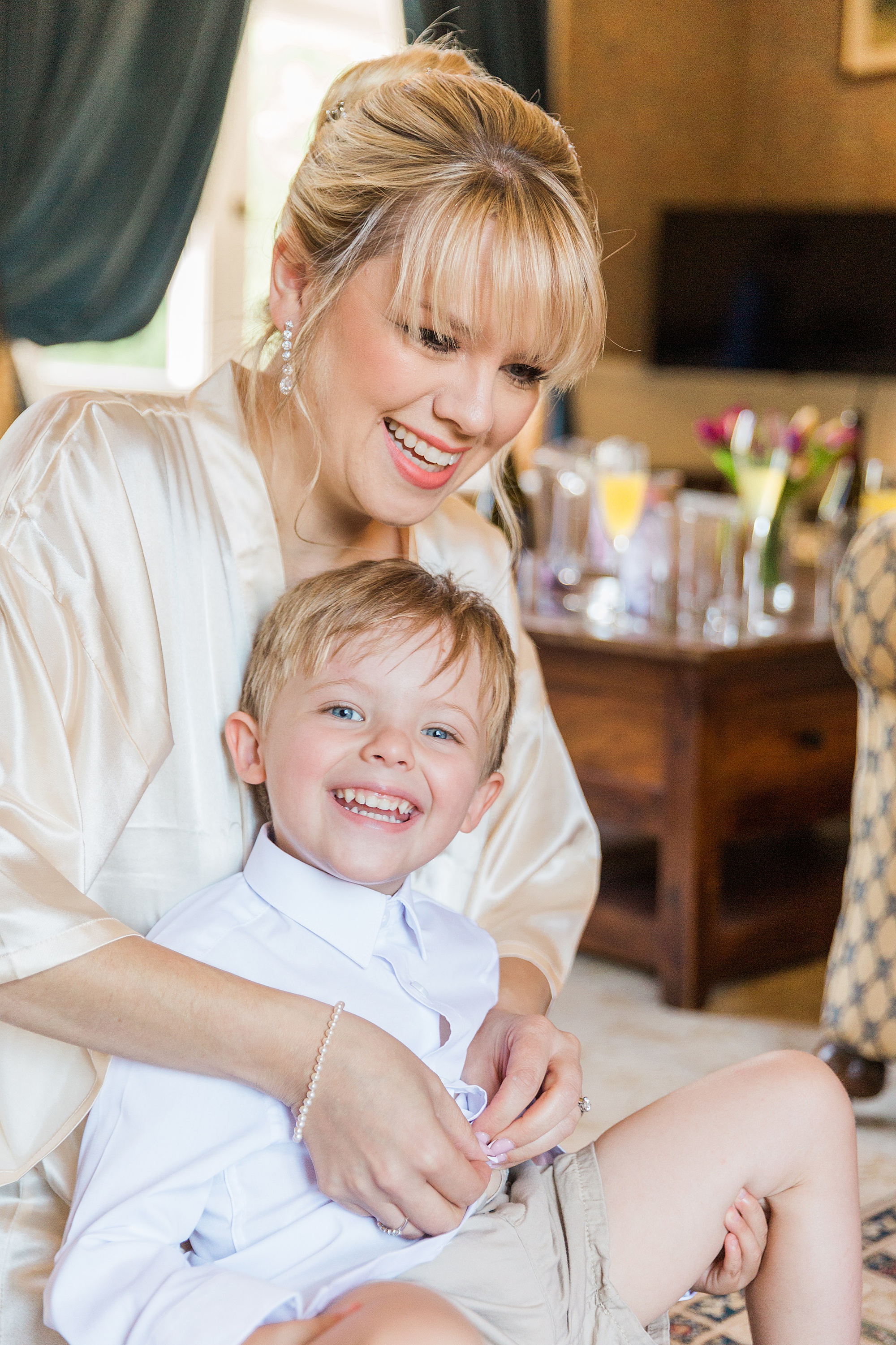 photo of her mum and son getting her son dressed before her wedding at grafton manor 