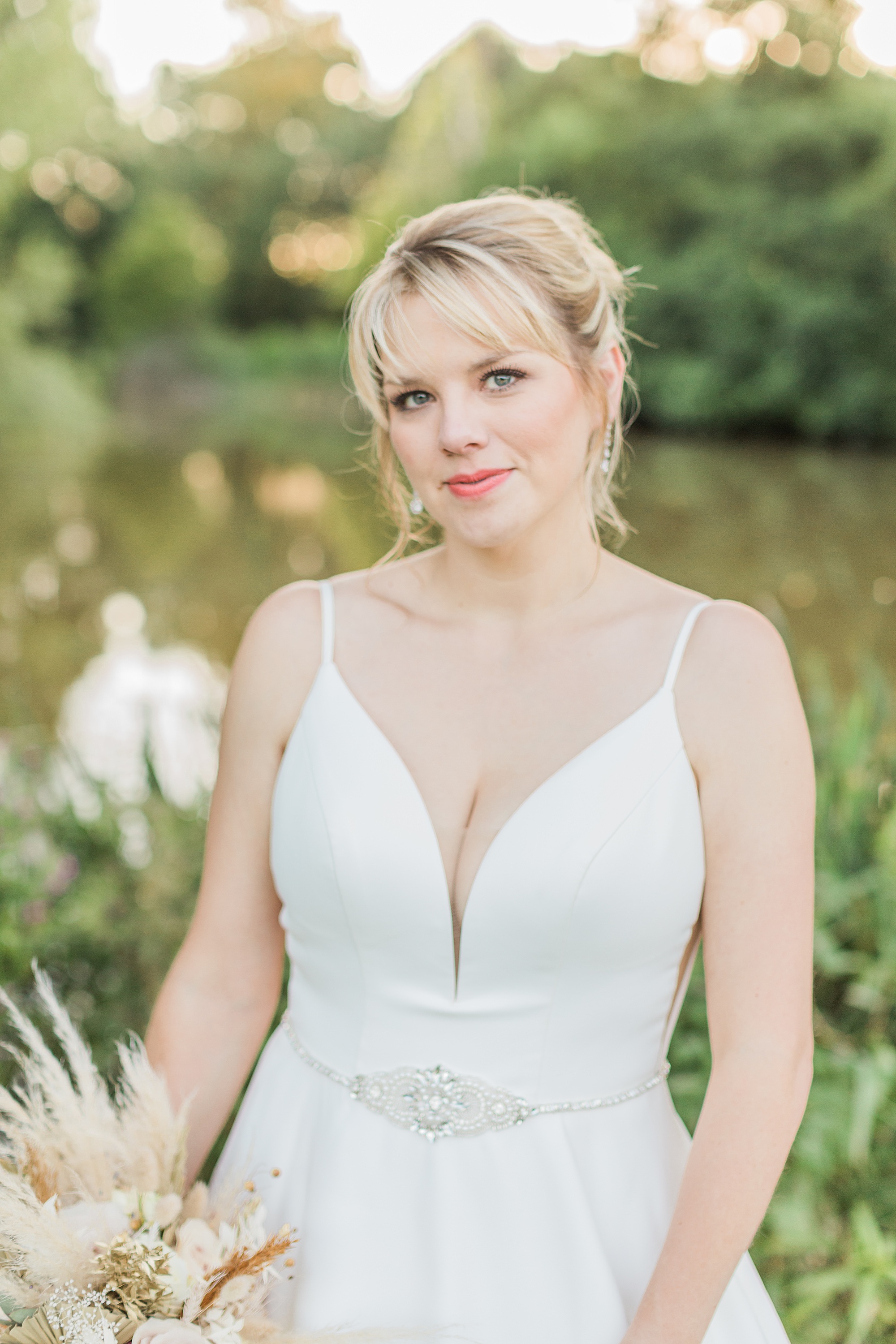 photo of a bride in her dress looking towards the camera with a closed mouth soft smile 