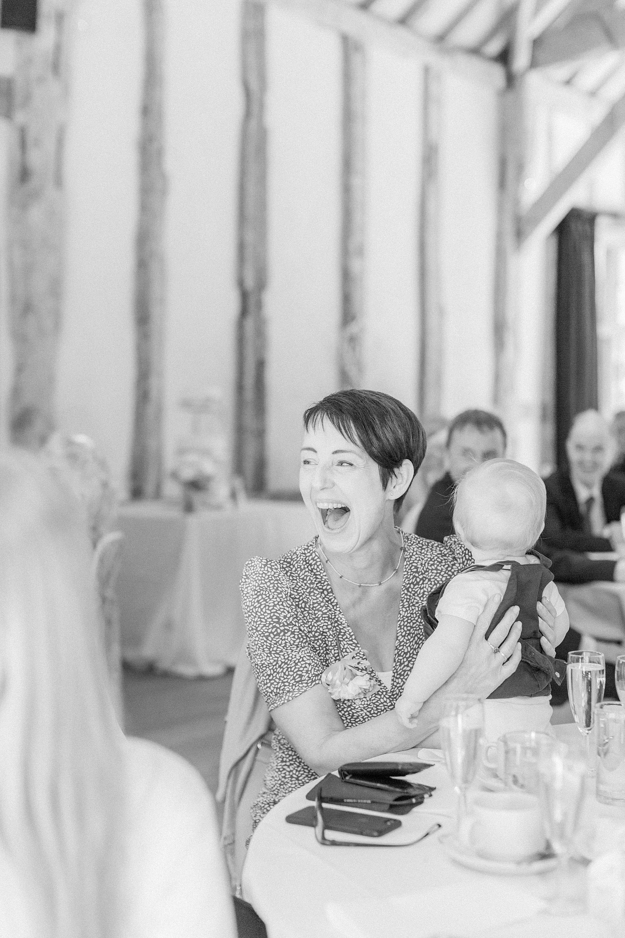 photo of a wedding guest's smiling and laughing reaction during the speeches 