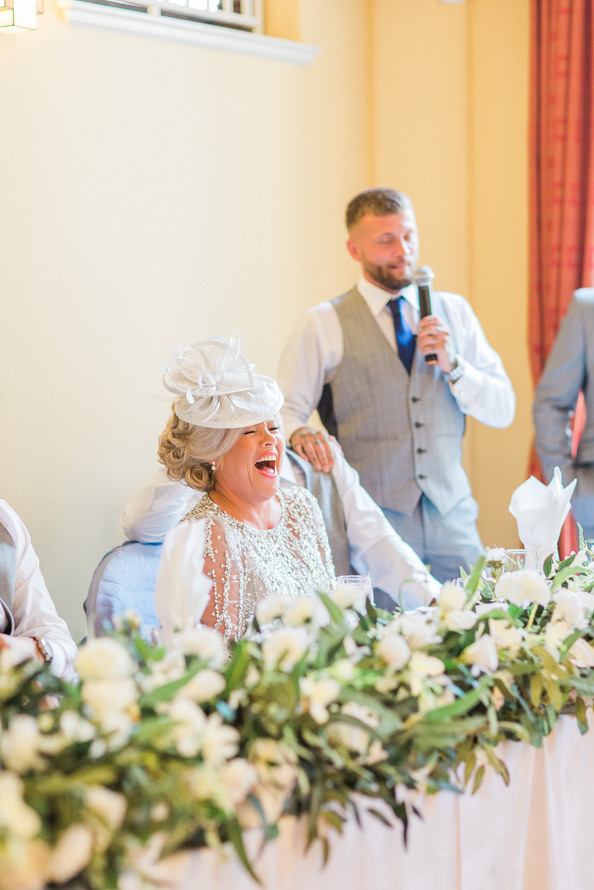 photo of a best man stood giving his speech at a wedding