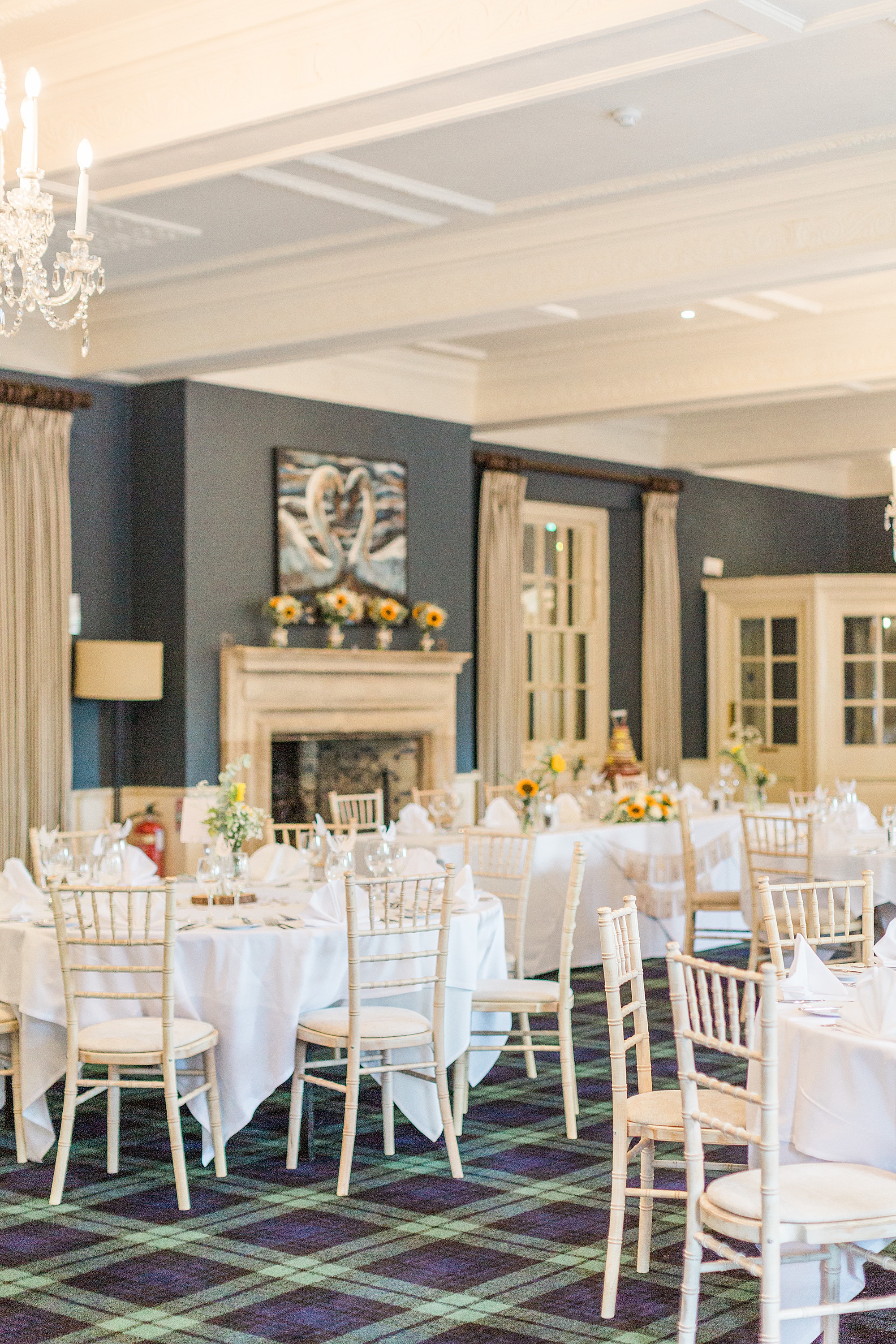 photo shows the inside of the wedding reception at the swan at bibury with beautiful navy decor and bright sunflowers 