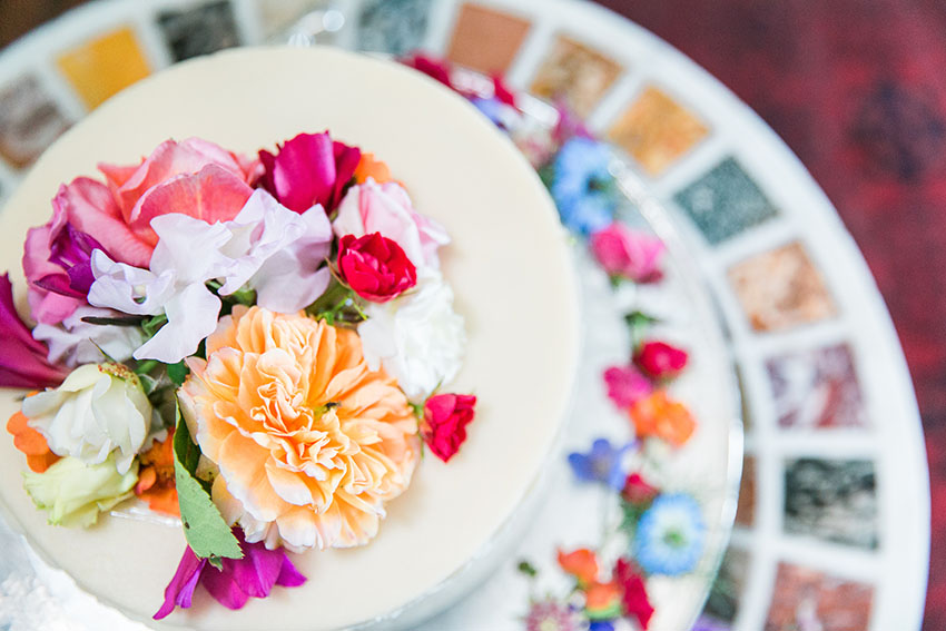 View of a wedding cake and colourful flowers taken from above